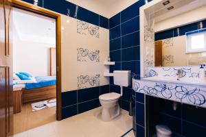 a blue bathroom with a toilet and a sink at Lak6 Apartment in Mórahalom