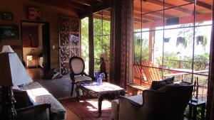 ein Wohnzimmer mit Sofas, einem Tisch und Fenstern in der Unterkunft Casa Hagan in Santa Cruz La Laguna