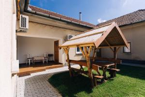 a wooden gazebo in the yard of a house at Lak6 Apartment in Mórahalom