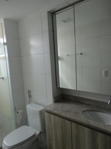 y baño con aseo, lavabo y espejo. en Flat Aconchegante Boa Viagem 2 Quartos, en Recife