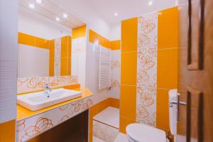 a bathroom with orange and white walls and a sink at Lak6 Apartment in Mórahalom