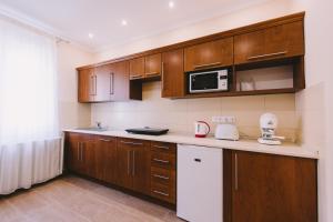 a kitchen with wooden cabinets and a microwave at Lak6 Apartment in Mórahalom