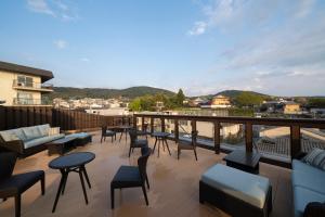 a patio with chairs and tables on a balcony at Terrace Kiyomizu Kyoto in Kyoto