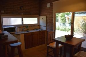 a kitchen with a sink and a table with a table at Cabañas Latitud 38.15 in Sierra de la Ventana