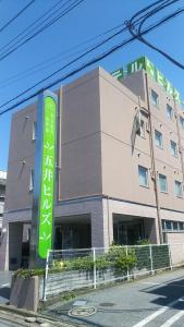 ein Gebäude mit einem grünen Schild davor in der Unterkunft Business Hotel Goi Hills in Ichihara