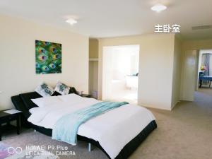 a bedroom with a large bed with a painting on the wall at Happy Cozy House in Point Cook
