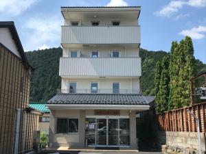 日光市にあるホテルファミテック 日光駅前の正面に看板がある背の高い白い建物
