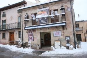 a building with a balcony with snow on it at Apartamentos Turisticos Casa Pastor in Riaza