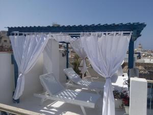a patio with two chairs and a gazebo at Dar Baaziz in Sousse