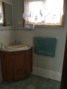 baño con lavabo, espejo y ventana en Millicent Lakeside Caravan Park, en Millicent