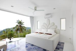 een witte slaapkamer met een witte bank en een groot raam bij Best world vision in Chaweng Beach