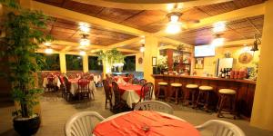 un restaurant avec des tables et des chaises ainsi qu'un bar dans l'établissement Mermaid Resort and Dive Center, à Puerto Galera
