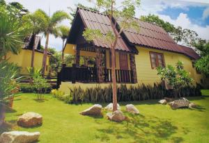 a yellow house with rocks in front of it at Prachuap Garden View Resort in Prachuap Khiri Khan