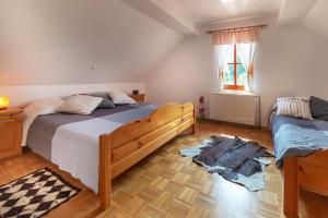 a bedroom with two beds and a wooden floor at PLANINCA -hiša z razgledom in Šmarje pri Jelšah
