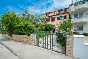 a fence in front of a building with pink flowers at Vila Dolores in Rovinj