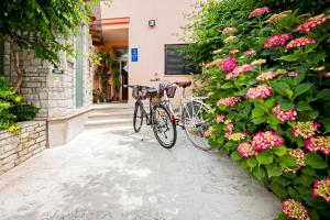 dos bicicletas estacionadas al lado de un edificio con flores en Vila Dolores, en Rovinj