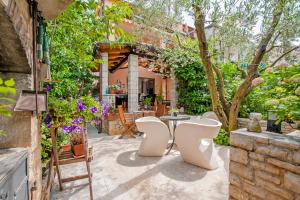 a patio with a table and chairs in a yard at Casa Botin in Rovinj
