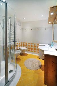 y baño con ducha, 2 lavabos y aseo. en Appartamenti da Nica e Diego en Borca di Cadore