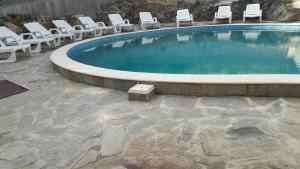 a swimming pool with lounge chairs and a bunch at Villa Ilchev in Sozopol
