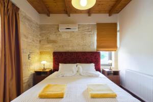 a bedroom with a bed with two yellow towels on it at Villas Kalives in Kalyves +63 photos