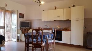 een keuken met witte kasten en een tafel met stoelen bij Villa Mancini - Locazione turistica in Polignano a Mare