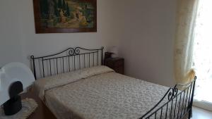 Un dormitorio con una cama y un cuadro en la pared. en Villa Mancini - Locazione turistica, en Polignano a Mare