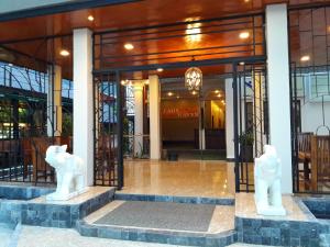 two white statues in front of a building at Laos Haven Hotel in Vang Vieng