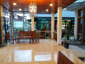 a lobby with a table and chairs and a chandelier at Laos Haven Hotel in Vang Vieng