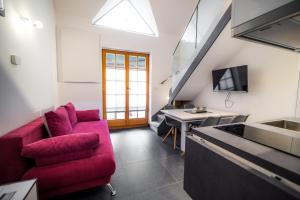 ein Wohnzimmer mit einem roten Sofa und einem Schreibtisch in der Unterkunft Golf apartment with SPA tickets discount in Moravske-Toplice