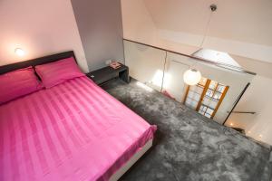 a bedroom with a pink bed and a window at Golf apartment with SPA tickets discount in Moravske-Toplice