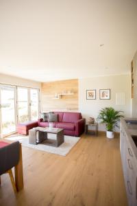 a living room with a red couch and a table at Ferienwohnung Vogelsang in Saalhausen