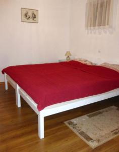 Una cama con una manta roja encima. en Thermal SPA Marija, en Topusko