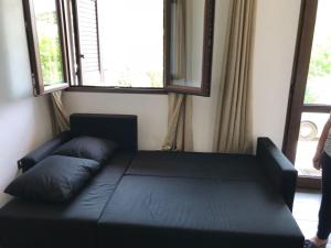 un letto nero in una stanza con finestre di Appartamento Rosmarino a Buggerru