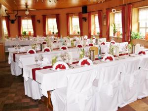 a row of tables in a room with white tablecloths at Hotel Auerhahn in Grevenkrug
