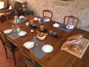 una mesa de madera con comida y pan. en La Pillebourdiere, en Oisly