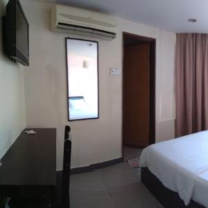 a bedroom with a bed and a television and a window at Starview Hotel in Lumut