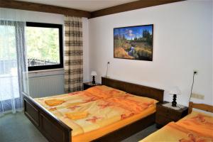 a bedroom with two beds and a painting on the wall at Penzion Sumavacek in Bayerisch Eisenstein +73 photos
