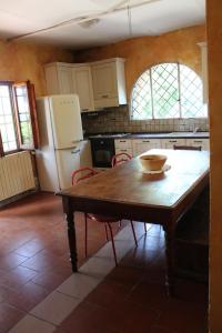een keuken met een houten tafel en een koelkast bij La Cascianella in Florence