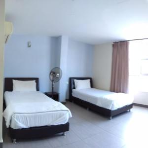 um quarto com 2 camas e uma janela em Starview Hotel em Lumut