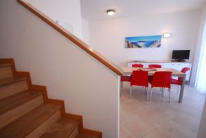 una sala da pranzo con tavolo e sedie rosse di Villa Palme a Lignano Sabbiadoro