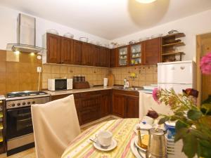 a kitchen with wooden cabinets and a table with a tablecloth on it at Apartments Maria 64 in Vodnjan