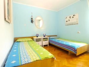 - 2 lits dans une chambre aux murs bleus dans l'établissement Apartments Maria 64, à Vodnjan