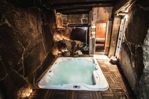 a bath tub in a room with a stone wall at Casa Rural Therma Agreste in Bermellar