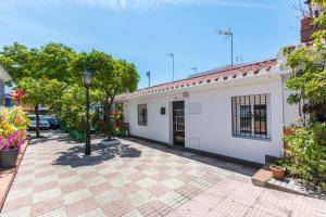 a white building with a courtyard with trees and flowers at Casa Alma in Marbella