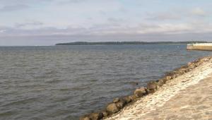 a body of water with a line of rocks on the shore at Ferienhaus Barbara Ehrhardt in Lühmannsdorf