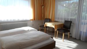 a hotel room with two beds and a table and chairs at Jogglerhaus in Lermoos