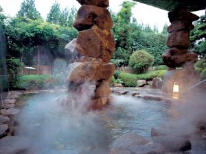 a water fountain in a garden with rocks at Yunogo Grand Hotel in Mimasaka