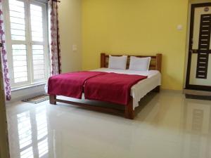 a bedroom with a bed with a red blanket at Maharaja Home Stay Panhala in Panhāla