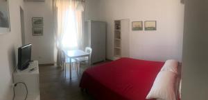 ヴィッラノーヴァ・ディ・オストゥーニにあるCasa Petrolla 126のベッドルーム(赤いベッド1台、テレビ付)