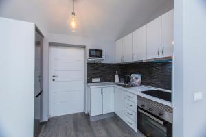 a kitchen with white cabinets and a white door at Casa Alma in Marbella